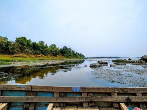 River view with green trees on left with boat Foto stock