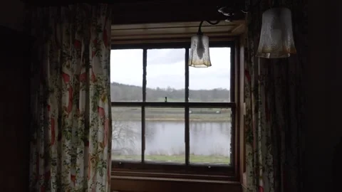 A river view out of an old rustic window with old fashioned curtains Stock Footage 267022089