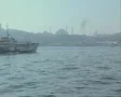 River view with passing boat and city in distance SD Footage