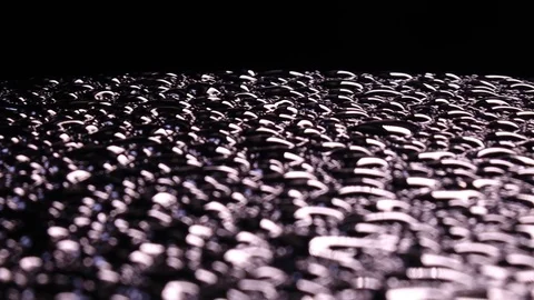 River of water drops with back focus on black background, moving to the left Stock-Footage 78351997