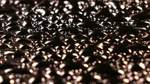 River of water drops on black surface, rotating to the right Video stock 78356180