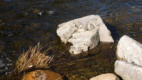River water flowing around boulder Stock Footage 128303562