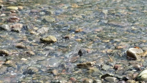 River water flowing through a bed of gravel rocks in a natural landscape Stock Footage 336828148