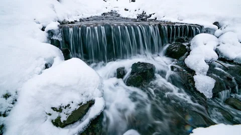 River water flows between the ice and snow in the mountains, natural pure Stock Footage 195925226