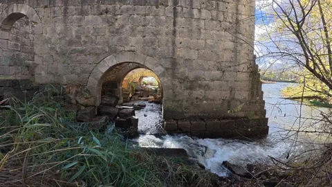 The river water flows between the ruins of an old stone mill Stock Footage 322183034