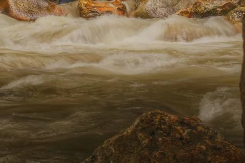 River water flows through rocks. Stock Photos