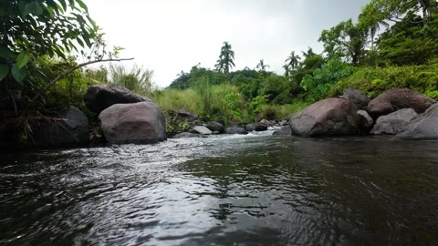 River water glides over rounded rocks.Ideal for nature documentaries. Vídeos de archivo 334628172