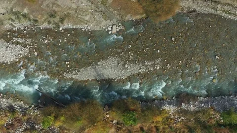 River water gracefully flowing through a rugged rocky landscape in a serene Vídeo Stock 305655209