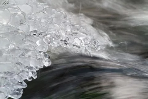River water is rapidly flowing out from under the ice Stock Photos