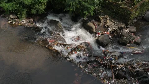 River water rapids flowing through accumulated plastic trash. Stock Footage 336313686