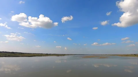 River water reflection with clear blue sky with many small cloud patch Stock Footage 129585354