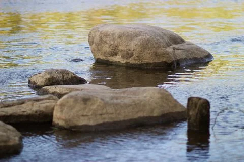 River water sharpens a large stone in its path Stock Photos