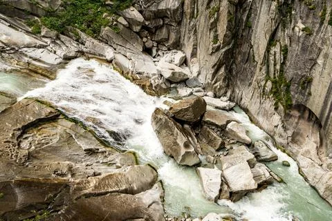 A river with a waterfall and rocks in the background in Switzerland Stock Photos