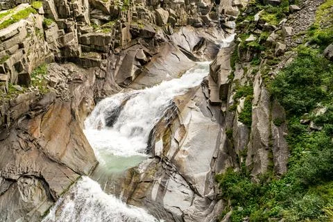 A river with a waterfall and rocks in the background in Switzerland Stock Photos