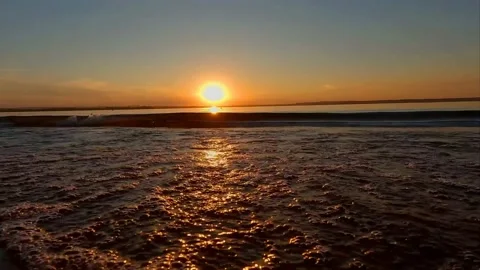 A river wave at sunset smoothly envelops the coast of the beach Stock Footage 219544452