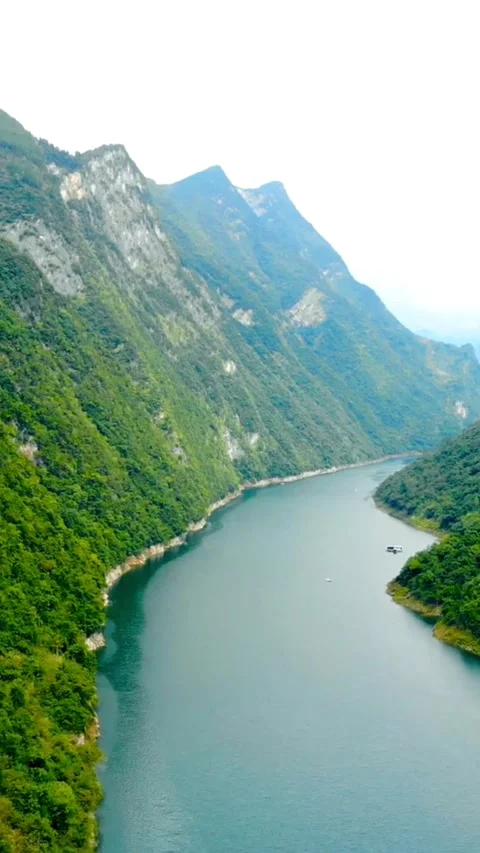 River winding through steep green mountains and lush forests Video stock 331932191
