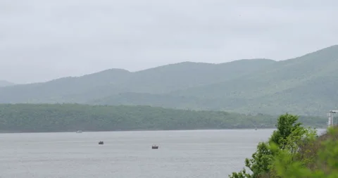 River winds between hills enveloped with dense green trees Vídeo Stock 320436953