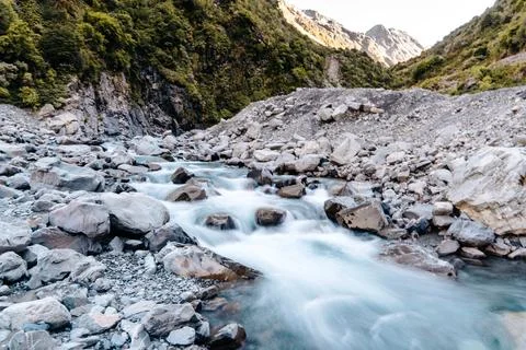 A river winds its way through a rocky mountain valley Stock Photos