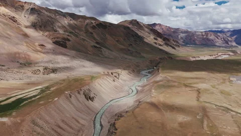 River Winds Through Arid Canyon Surrounded by Rugged Mountains Stock Footage 311041752