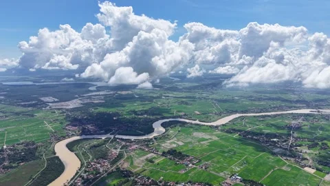 River winds through lush green fields under vast clouds Video stock 338992283