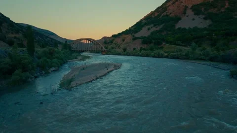 River winds through rocky terrain as sun dips below horizon Stock-Footage 332366565