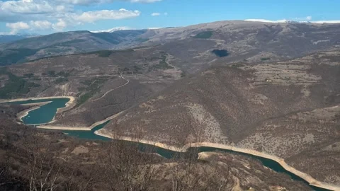 River winds through rugged, brown mountains. Balkan, Eastern Europe, POV Stock Footage 331814013