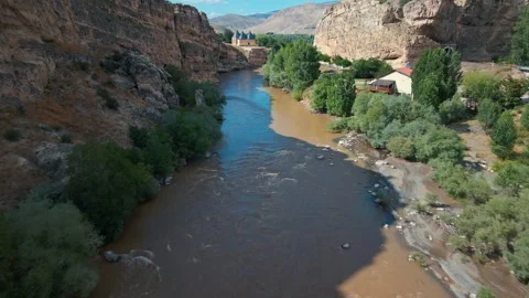 River winds through rugged canyon, flanked by ancient stone walls 스톡 동영상 332498379