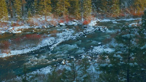 River in winter with fresh show in late afternoon sun - panning. Stock Footage 171449108