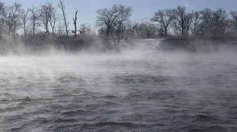 A river in the winter time with mist rising over rushing water.  Stock Footage 60644469