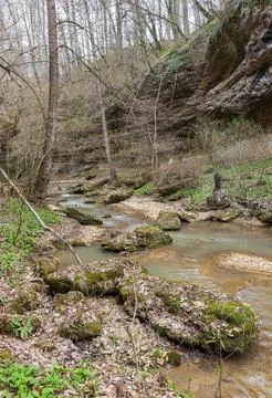 A riverbed with an exposed rocky bottom, a small stream and a current of wate Foto stock