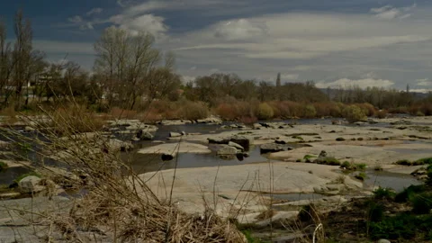 Riverbed with low water exposing large flat rocks and puddles Stock Footage 335462182
