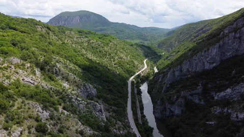 Riverbed, traffic road and trail between two mountains. Aerial view 動画素材 133014863