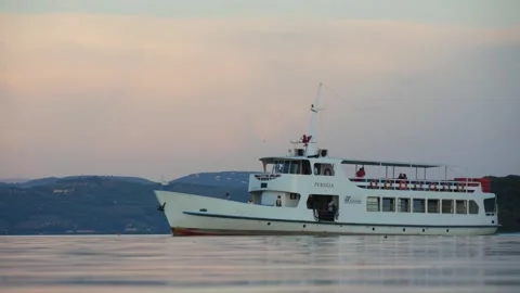 A Riverboat With Few Passengers Passing on the Calm Water Surface in the Evening Stock Footage 245282268