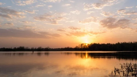 Rivers of blue clouds on an orange sky. Ripple wave on water surface. Video stock 91583016