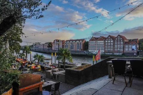Riverside cafe terrace with string lights - Bremen, Germany 28.07.2024 Stock Photos