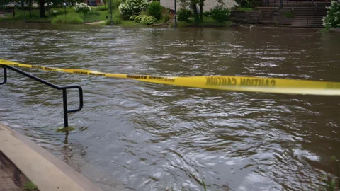 Riverside of flooded river with the yellow caution tape. Heavy rains caused Stock-Footage 317208608