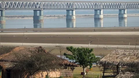 Riverside huts with bridge in background Stock Footage 331277699