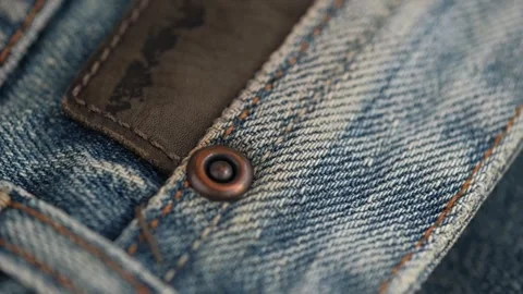 Rivet and decorative patch made of genuine leather on denim trousers. rotating Stock-Footage 246785371