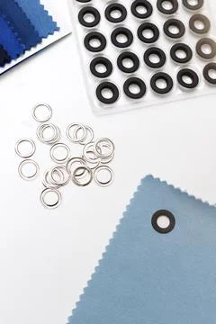 Rivets, fabric on a white table Foto stock