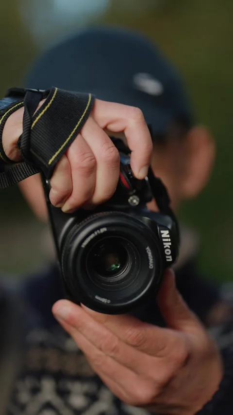 Rivne, Ukraine - June 24, 2024: Close-up of a person holding a SLR camera Stock Footage 307142453