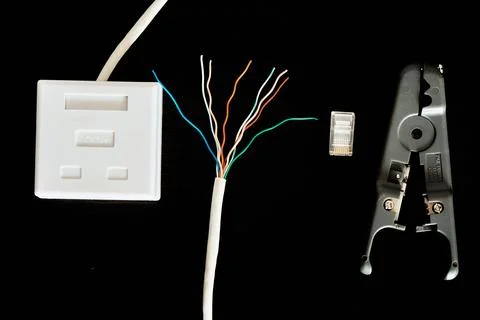 RJ45 connector, twisted pair, socket, insulation stripper on a dark backgroun Stock Photos
