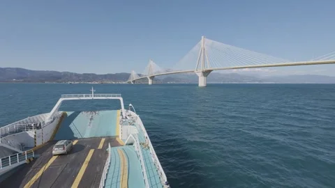 Ro-ro ferry moving under Rio Antirrio bridge with rough sea view Stock Footage 338106959