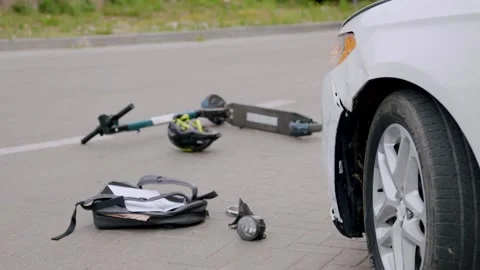 A road accident between a luxury white car and an electric scooter on an asphalt Stock Footage 248174836