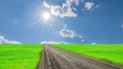 Road across a green fields time lapse scene Video stock 273769893