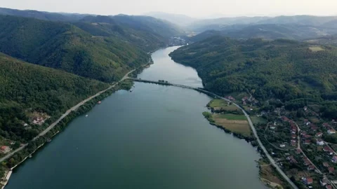 A road across river Danube surrounded by green wooded hills near small town Stock-Footage 263144273