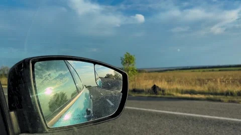 Road adventure. View in the rear view mirror of a car. Road trip. Summer car Video stock 312724862