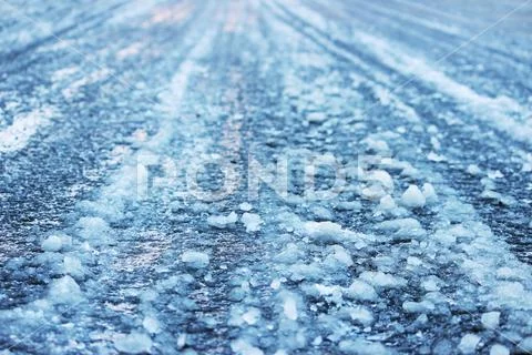 Road after thaw and frost covered with slippery ice icy. Stock Photos
