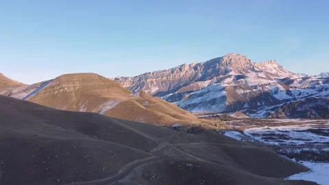 Road along the mountains in winter Stock Footage 168980471