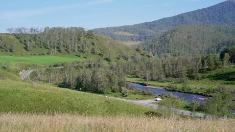 The road along the river located between the green hills 스톡 동영상 79731845