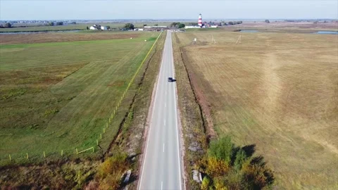 The road along which the car is driving, on the sides of the field, top view Vidéo 167064233